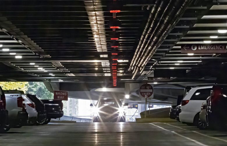 A car drives on the second floor of the parking garage at Seattle-Tacoma International Airport parking Monday, November 21, 2022.  Red lights indicate that parking spaces are filled.
Parking reservations are sold out at the airport for the Thanksgiving and Christmas holidays.

 222243