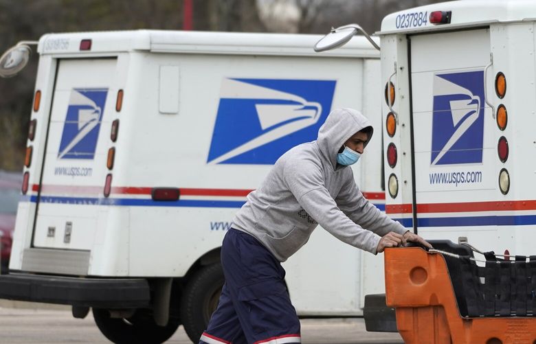 FILE – A United States Postal Service employee works outside a post office in Wheeling, Ill., Dec. 3, 2021.  The nationâ€™s major shipping companies are in the best shape to get holiday shoppersâ€™ packages delivered on time since the start of the pandemic, suggesting a return to normalcy. (AP Photo/Nam Y. Huh, File) NYBZ801 NYBZ801