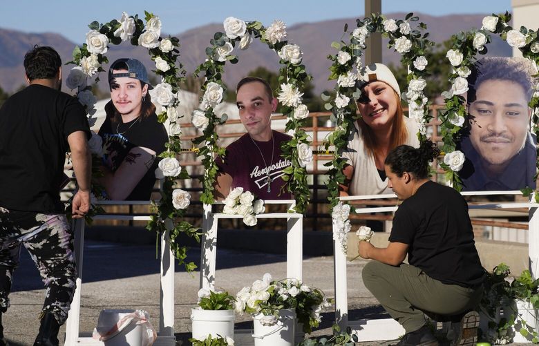 Noah Reich, left, and David Maldonado, the Los Angeles co-founders of Classroom of Compassion, put up a memorial with photographs of the five victims of a weekend mass shooting at a nearby gay nightclub on Tuesday, Nov. 22, 2022, in Colorado Springs, Colo.  Anderson Lee Aldrich opened fire at Club Q,  in which five people were killed and others suffered gunshot wounds before patrons tackled and beat the suspect into submission.   (AP Photo/David Zalubowski) CODZ102 CODZ102