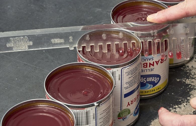 The level of cranberry in cans is inspected at the Ocean Spray production facility in Kenosha, Wis., Oct. 13, 2022. In 1930, three cranberry farmers established the Ocean Spray cooperative and their canned jellied sauce became available nationwide in 1941. The cooperative has now grown to be owned by 700 family farmers. (Ross Mantle/The New York Times) XNYT268 XNYT268
