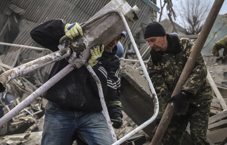 Ukrainian volunteers clear debris at a damaged maternity hospital in Vilniansk, Zaporizhzhia region, Ukraine, Wednesday, Nov. 23, 2022. A Russian rocket struck the maternity wing of a hospital in eastern Ukraine on Wednesday, killing a newborn boy and critically injuring a doctor. The overnight explosion left the small-town hospital a crumbled mess of bricks, scattering medical supplies across the small compound. (AP Photo/Kateryna Klochko) XSG132 XSG132