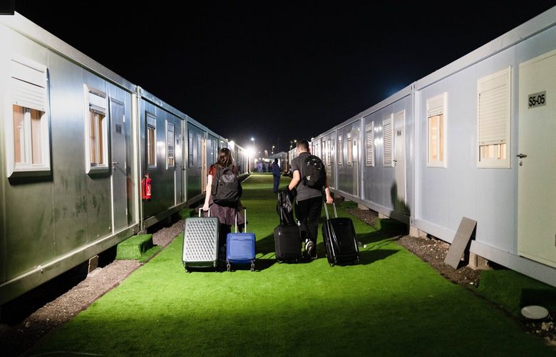 Gihana Fava and Renan Almeida, soccer fans from Brazil, head for their rented room after checking in at Fan Village at the World Cup in Doha, Qatar, on Nov. 22, 2022. Fan Village is a sea of shipping containers converted to sleeping quarters, stretching almost as far as the eye can see. (Erin Schaff/The New York Times) XNYT161 XNYT161