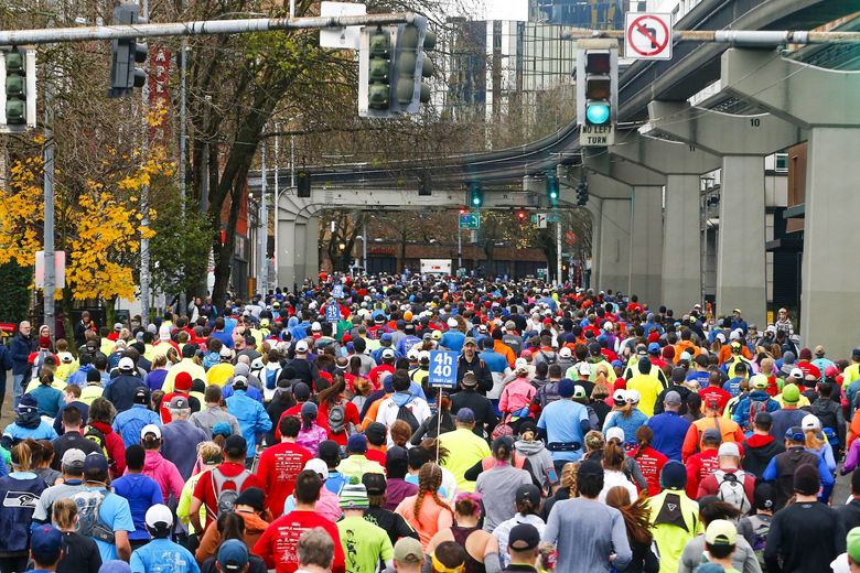 Competitors young and old make their way from the starting line 26.2 miles through downtown for the Seattle Marathon in 2016. This year’s race follows roads and trails around the University of Washington instead of downtown. (Logan Riely / The Seattle Times, file)