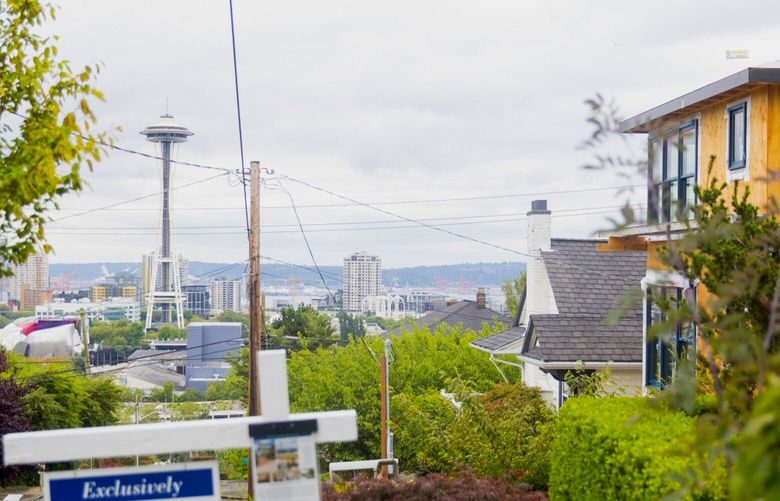 The Space Needle stands past a “For Sale” sign displayed in front of a house in Seattle, Washington, U.S., on Sunday, July 20, 2014. Sales of previously owned U.S. homes climbed in June to an eight-month high as more listings helped prices cool, luring buyers into the market. Photographer: Mike Kane/Bloomberg 503031845