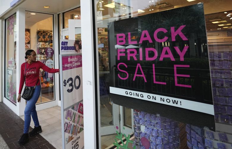 Shoppers exit a Claire’s accessories store advertising sales ahead of Black Friday and the Thanksgiving holiday, Monday, Nov. 21, 2022, in Miami. Retailers are ushering in the start of the holiday shopping season on the day after Thanksgiving, preparing for the biggest crowds since 2019. (AP Photo/Rebecca Blackwell) FLRB106 FLRB106