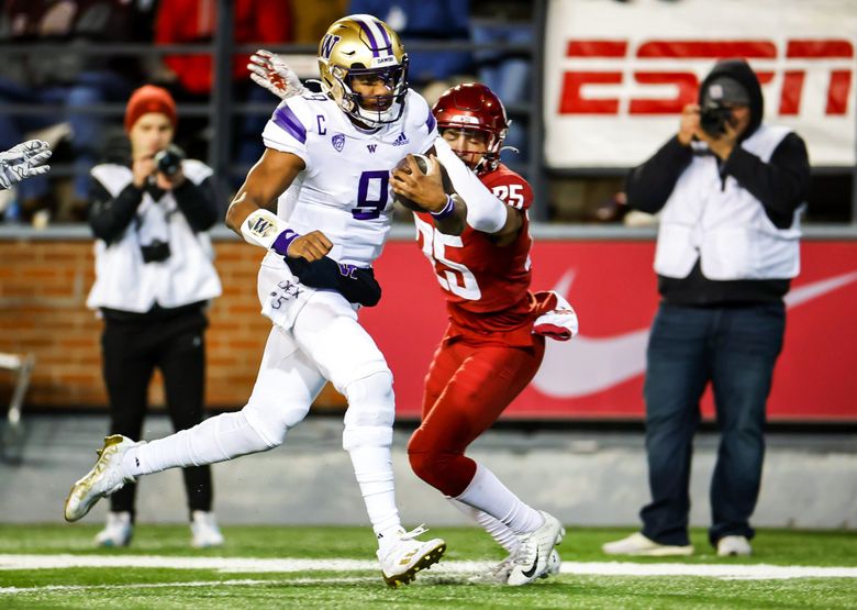 Washington quarterback Michael Penix Jr. runs in a touchdown past Washington State defensive back Jaden Hicks after receiving a pass from Jalen McMillan in the second quarter as the Washington Huskies played the Washington State Cougars in Pac-12 Football Saturday, November 26, 2022 at Martin Stadium, in Pullman, WA. (Dean Rutz / The Seattle Times)