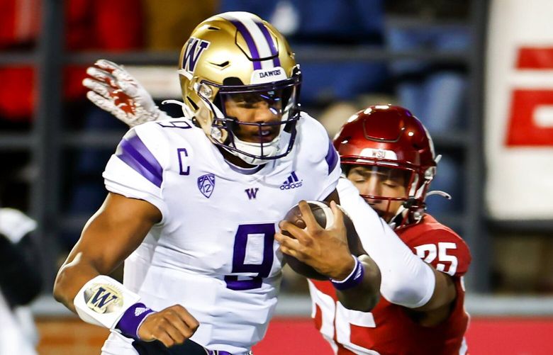 Washington quarterback Michael Penix Jr. runs in a touchdown past Washington State defensive back Jaden Hicks after receiving a pass from Jalen McMillan in the second quarter as the Washington Huskies played the Washington State Cougars in Pac-12 Football Saturday, November 26, 2022 at Martin Stadium, in Pullman, WA.  222254