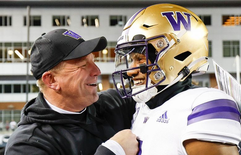 Kalen DeBoer grabs Michael Penix Jr. after the Huskies defeated the Cougars in the annual Apple Cup game. 222254