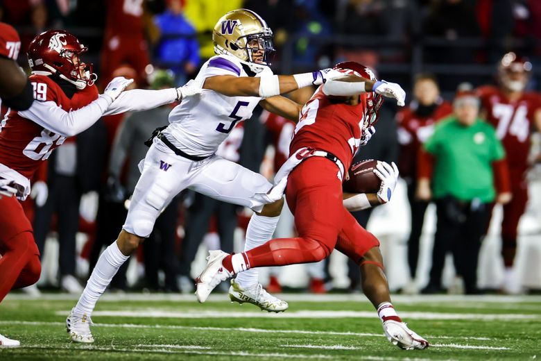 Washington safety Alex Cook tries to get hold of Washington State running back Nakia Watson on the opening drive as the Washington Huskies play the Washington State Cougars in Pac-12 Football Saturday, November 26, 2022 at Martin Stadium, in Pullman, WA. (Dean Rutz / The Seattle Times)