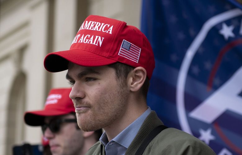 FILE – Nick Fuentes, far-right activist, holds a rally at the Lansing Capitol, in Lansing, Mich., Nov. 11, 2020. Former President Donald Trump had dinner Tuesday, Nov. 22, 2022, at his Mar-a-Lago club with the rapper formerly known as Kanye West, who is now known as Ye, as well as Nick Fuentes, who has used his online platform to spew antisemitic and white supremacist rhetoric. (Nicole Hester/Ann Arbor News via AP, File) MIARB101 MIARB101
