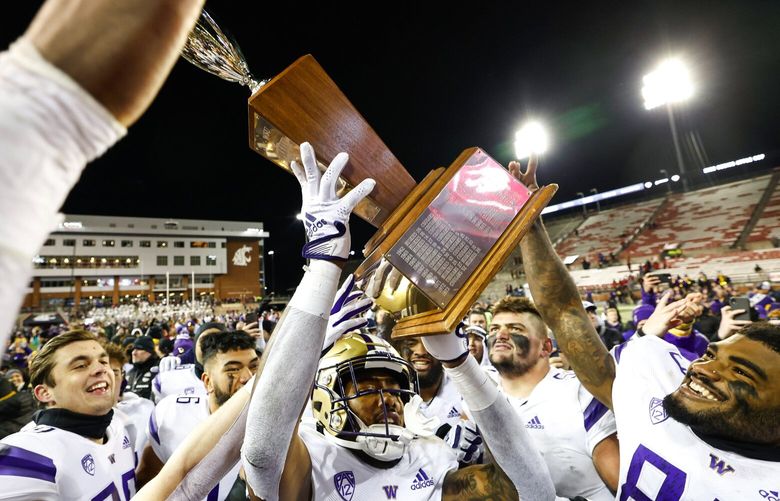 Players hoist the trophy after the Washington Huskies beat the Washington State Cougars 51-33 in the Apple Cup Saturday, November 26, 2022 at Martin Stadium, in Pullman, WA.  222254