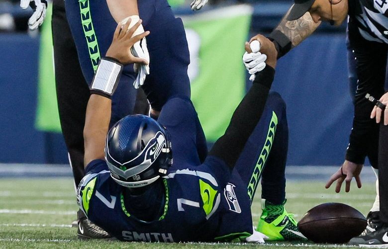 Seattle Seahawks center Austin Blythe (63) and offensive tackle Abraham Lucas (72) puck up quarterback Geno Smith off the turf after Smith took a sack during the fourth quarter. 222269