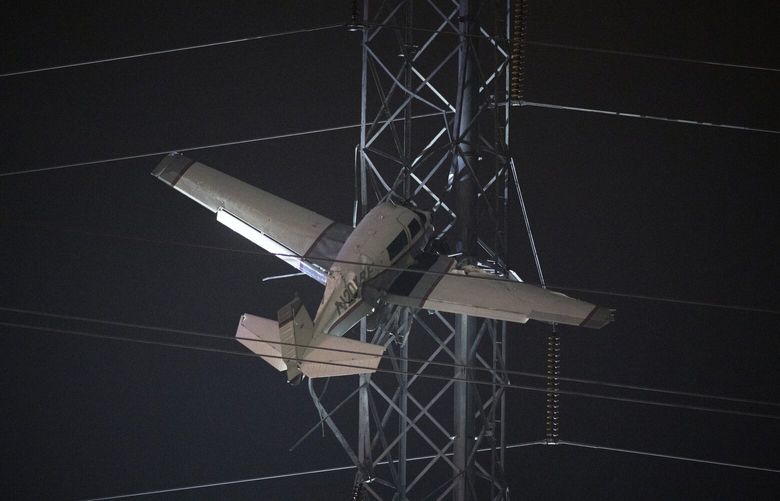 A small plane rests on live power lines after crashing, Sunday, Nov. 27, 2022, in Montgomery Village, a northern suburb of Gaithersburg, Md. (AP Photo/Tom Brenner) MDTB701 MDTB701