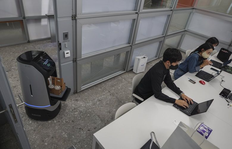 A robot making a coffee delivery at the offices of Naver, an internet firm, on the outskirts of Seoul, South Korea, Sept. 28, 2022. Naver is trying to introduce robots into the world of cubicles and conference rooms without making employees uncomfortable. (Chang W. Lee/The New York Times) XNYT221 XNYT221