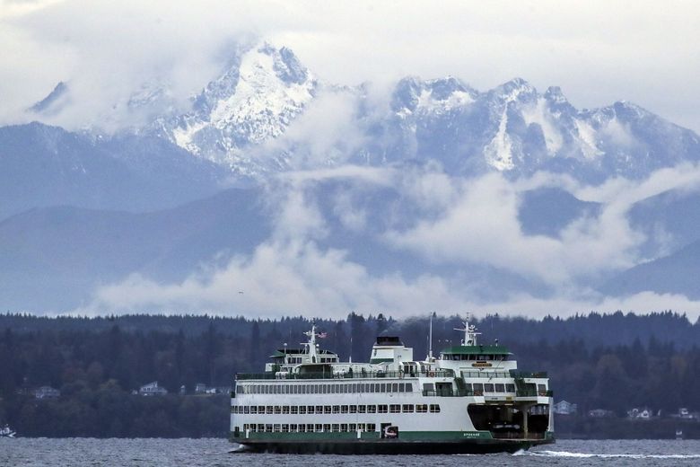 The snow-capped Olympic mountains frame a ferry making the Edmonds-Kingston run recently on Puget Sound. Snow could be seen in the lowlands this week.   (Kevin Clark / The Seattle Times)