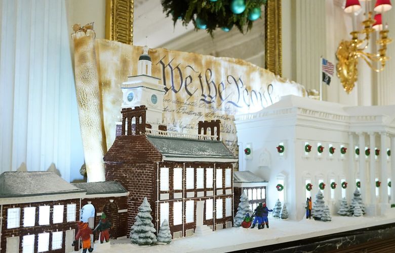 A sugar cookie replica of Independence Hall and a gingerbread replica of the White House are on display in the State Dining Room of the White House during a press preview of holiday decorations at the White House, Monday, Nov. 28, 2022, in Washington. (AP Photo/Patrick Semansky) DCPS103 DCPS103