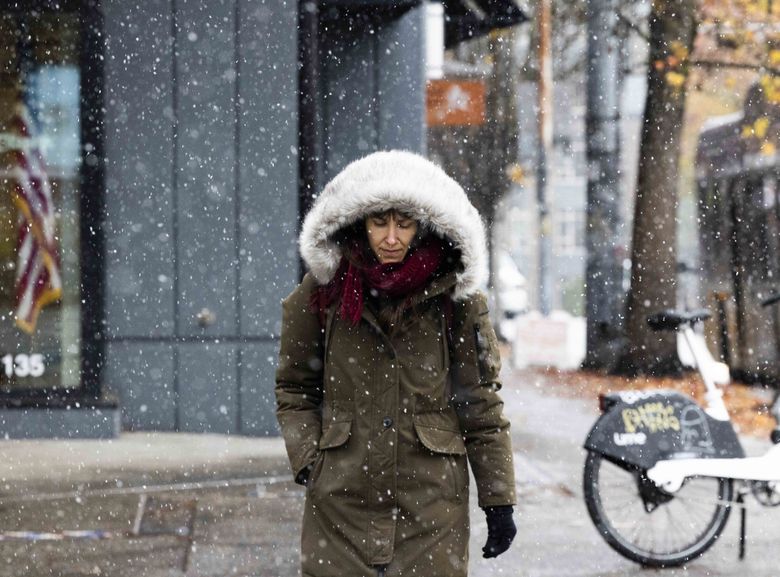 Ana Isabel Frias bundles up as she walks through a snowy Capitol Hill on Tuesday.  (Daniel Kim / The Seattle Times)