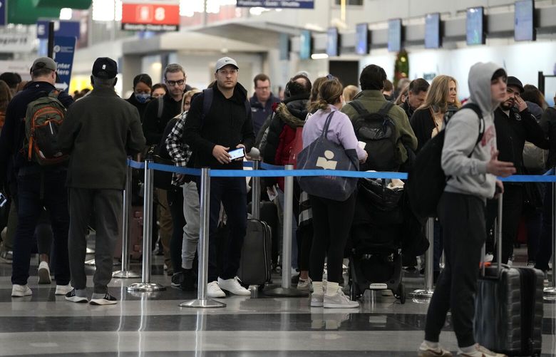 Travelers wait to go through security check point at O’Hare International Airport in Chicago, Wednesday, Nov. 23, 2022. (AP Photo/Nam Y. Huh) ILNH115 ILNH115