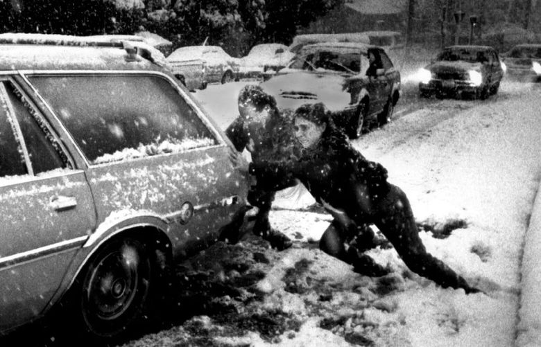 Passing motorists try to help a stranded driver up the northbound on-ramp at Northeast 50th Street and Interstate 5 on Dec. 19, 1990.