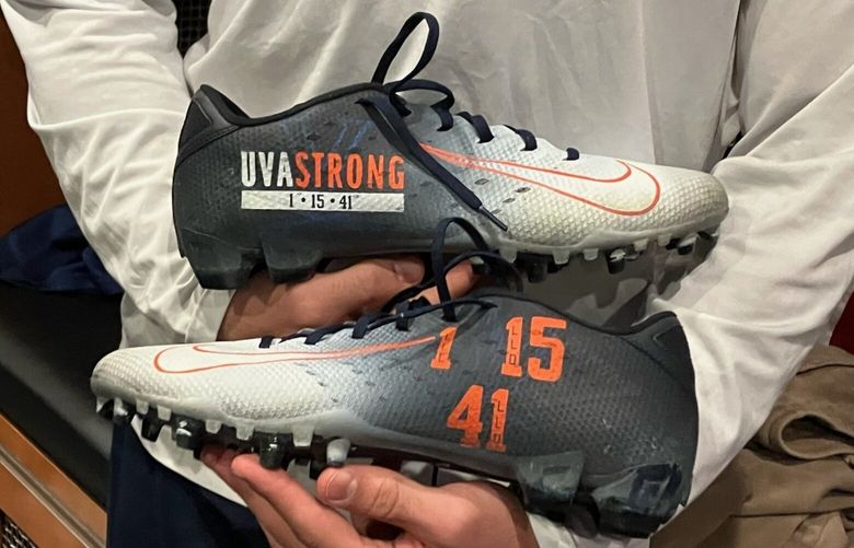 Seahawks safety Joey Blount holds his personalized cleats in tribute of the three University of Virginia football players who were killed on Nov. 13.