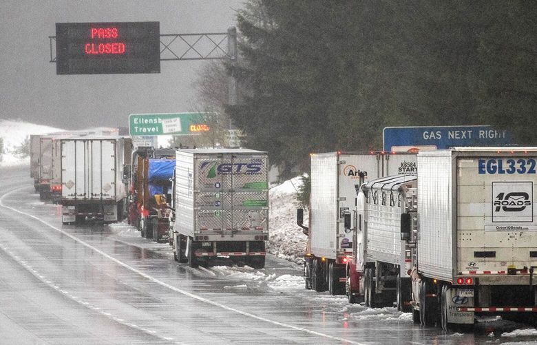 Trucks park along the side of Interstate 90 near North Bend as Snoqualmie Pass remains closed on Thursday, Jan. 6, 2022. The three primary cross-state mountain passes ó Stevens, Snoqualmie and White ó are closed.