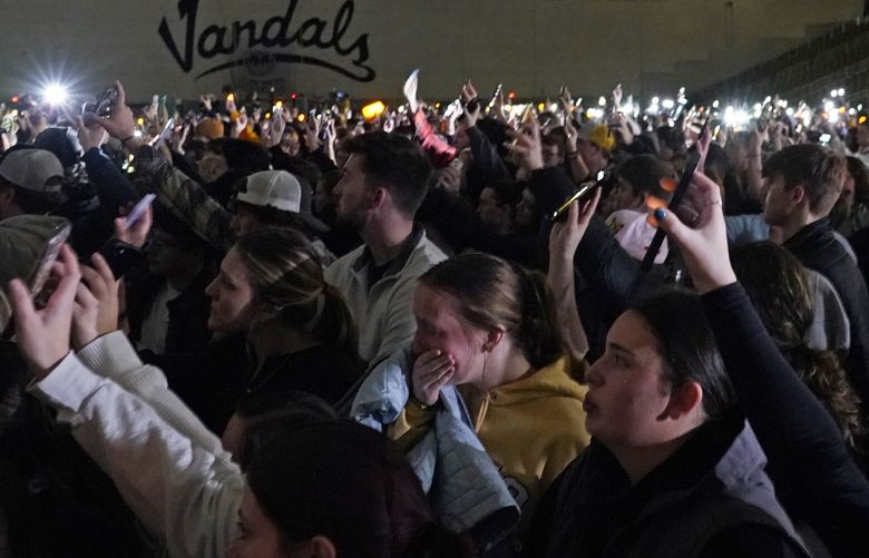 People attending a vigil for the four University of Idaho students who were killed on Nov. 13, 2022, hold up their phones during a moment of silence, Wednesday, Nov. 30, 2022, in Moscow, Idaho. (AP Photo/Ted S. Warren) IDTW202 IDTW202