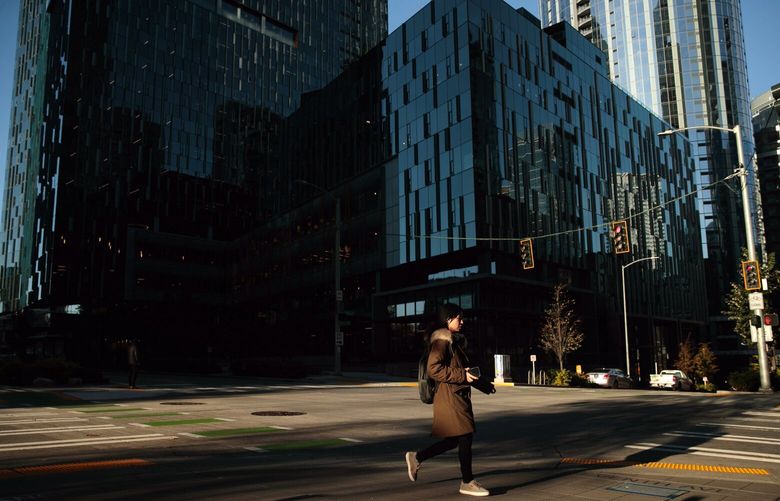 A pedestrian walks by Amazon’s offices at the corner of Seventh Avenue and Blanchard Street in Seattle on Tuesday, Nov. 15, 2022. 222198