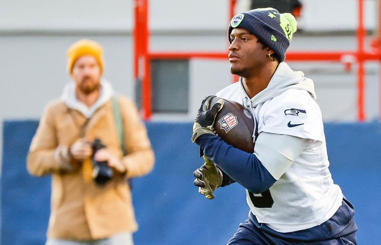 Running back Kenneth Walker III takes the handoff from Geno Smith as the Seahawks work out for the first time since arriving in Germany Thursday. 222159
