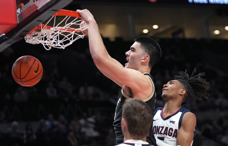 Purdue center Zach Edey dunks against Gonzaga guard Hunter Sallis, right, during the first half of an NCAA college basketball game in the Phil Knight Legacy tournament Friday, Nov. 25, 2022, in Portland, Ore. (AP Photo/Rick Bowmer) UTRB145 UTRB145