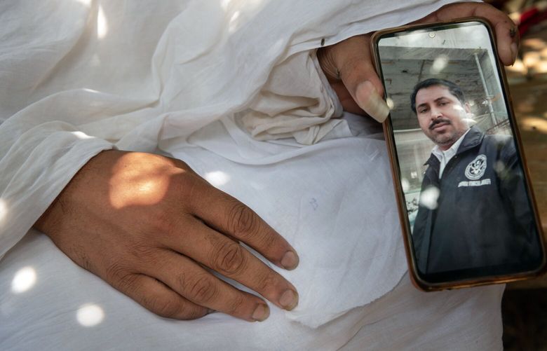 Ram Bikash displays a photo of his father, Rakesh Kumar Yadav, in Dhamaura, Nepal, on April 14, 2022. Yadav, a 40-year-old Nepali, died three months after arriving in Dubai to work as a security guard. (Saumya Khandelwal/The New York Times) XNYT89 XNYT89