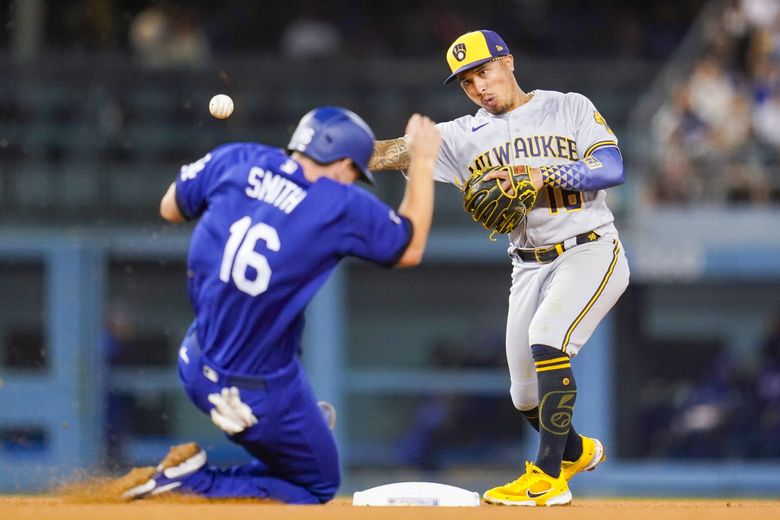 Milwaukee Brewers second baseman Kolten Wong throws to first for a double play against the Dodgers, Aug. 22, 2022, in Los Angeles. (Ashley Landis / AP)