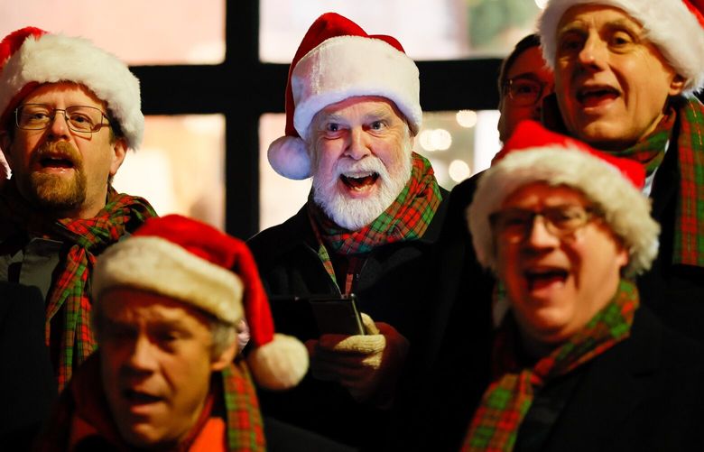Members of the Seattle SeaCordsmen finish off a carol with smiles during the 37th Annual Great Figgy Pudding Caroling Celebration at Pike Place Market on Friday night. The competition benefits the Pike Market Senior Center & Food Bank. 222197