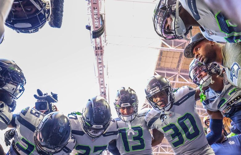 The Seahawks defensive unit huddle up before taking the field Sunday. 222116