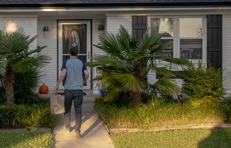 Paul Rizzo drops off a food delivery order in Kenner, La., Nov. 28, 2022. For the past five months Rizzo has been delivering food and groceries through the DoorDash app. (Emily Kask/The New York Times)