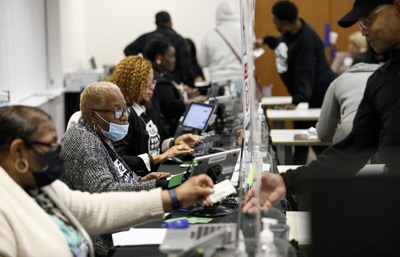 Poll workers check voters in to cast their ballots at the Metropolitan Library in Atlanta on Friday, Dec. 2, 2022. The contest between the incumbent Sen. Raphael Warnock (D-Ga.) and Herschel Walker might have been a showcase of Black political power in the Deep South, but many Black voters say Walker’s turbulent campaign has marred the moment. (Dustin Chambers/The New York Times) XNYT52 XNYT52
