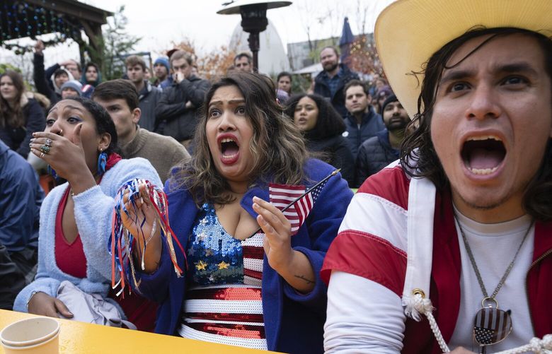 Fans of the United States soccer team, from right,Patricio Pichling, Eesha Pendharkar and Dania Abdalla react as they watch on television at a bar in Washington the United States team play against the Netherlands during their World Cup soccer match, Saturday, Dec. 3, 2022. (AP Photo/Manuel Balce Ceneta) DCMC105 DCMC105