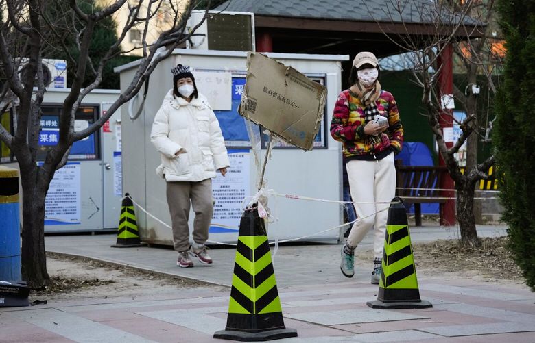 Residents walk away after finding COVID test stations unexpectedly closed in Beijing, Saturday, Dec. 3, 2022. Chinese authorities on Saturday announced a further easing of COVID-19 curbs with major cities such as Shenzhen and Beijing no longer requiring negative tests to take public transport. (AP Photo/Ng Han Guan) XHG120