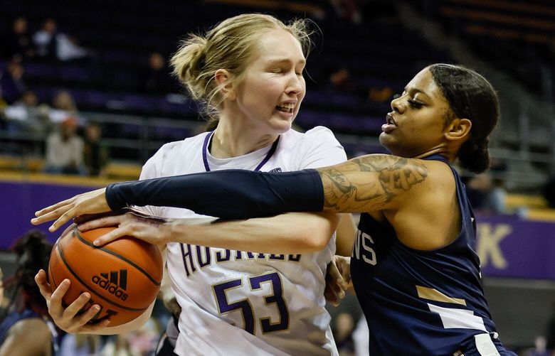 Washington Huskies center Darcy Rees keeps the ball away from Queens guard Adia Brisker during the third quarter. 222373