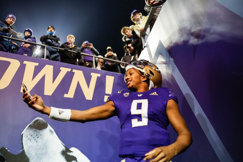 Michael Penix II does a selfie for fans just outside the Husky tunnel following Saturday’s 54-7 win over Colorado. (Dean Rutz / The Seattle Times)