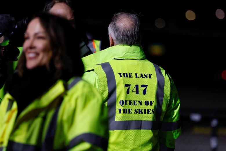 A Boeing employee wears a safety jacket honoring “The last 747 Queen of the Skies” after the 747 rolled out of the Everett factory Tuesday night. (Jennifer Buchanan / The Seattle Times)