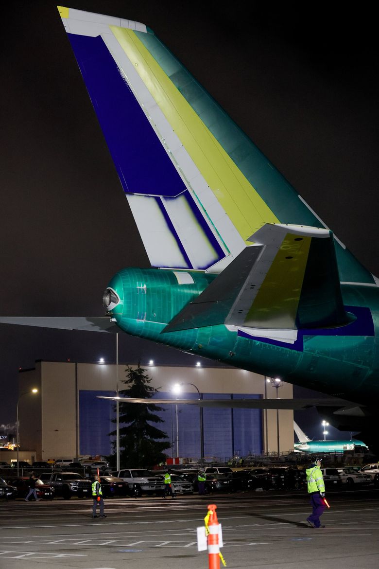 The massive tail of the final Boeing 747 aircraft rolls past the hangar at the Everett factory Tuesday night. The 747-8 tail height is 63 feet 6 inches, equivalent to a six-story building. (Jennifer Buchanan / The Seattle Times)