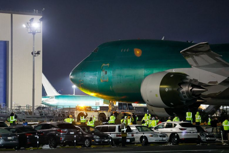The final Boeing 747 aircraft makes it way across the Boeing Freeway after it is rolled out of the hangar at the Everett factory for the first time Tuesday night. The 747-8 is able to travel the length of a standard 26.2-mile marathon in 2.5 minutes. (Jennifer Buchanan / The Seattle Times)