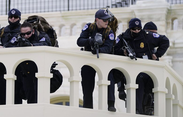 FILE – Police keep a watch as insurrectionists loyal to President Donald Trump try to break through a police barrier at the Capitol in Washington, Jan. 6, 2021. Top House and Senate leaders will present law enforcement officers who defended the U.S. Capitol on Jan. 6, 2021, with Congressional Gold Medals on Wednesday, Dec. 7, 2022, awarding them Congress’s highest honor nearly two years after they fought with former President Donald Trumpâ€™s supporters in a brutal and bloody attack. (AP Photo/Julio Cortez, File) WX208 WX208