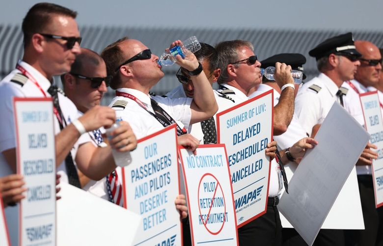 Southwest Airlines pilots drink water while picketing for better work conditions on June 21, 2022, outside Dallas Love Field. (Rebecca Slezak/The Dallas Morning News/TNS)