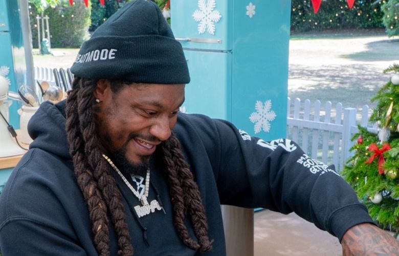 Marshawn Lynch measures milk while competing in the Great American Baking Show’s holiday special.
