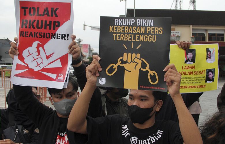 Activists hold up posters during a rally against Indonesia’s new criminal law in Yogyakarta, Indonesia, Tuesday, Dec. 6, 2022. The country’s parliament passed the long-awaited and controversial revision of its penal code Tuesday that criminalizes extramarital sex for citizens and visiting foreigners alike. Writings on the posters read “Reject the revised penal code” and “Revised criminal law shackles press freedom.” (AP Photo/Slamet Riyadi) JAK108 JAK108