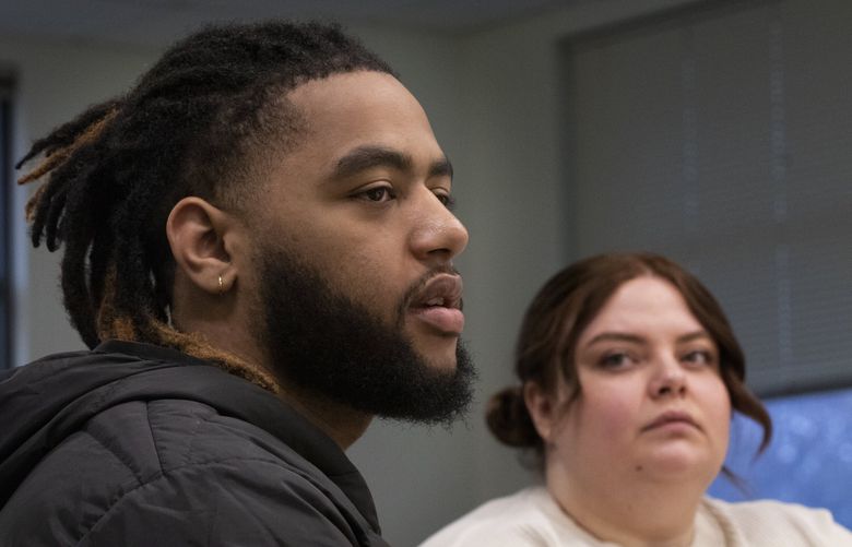 Amir Yusuf talks during a meeting at Treehouse last month. He is one of the young adults who was served by Treehouse as a youth. At right is Katie Buxton. (Ellen M. Banner / The Seattle Times)