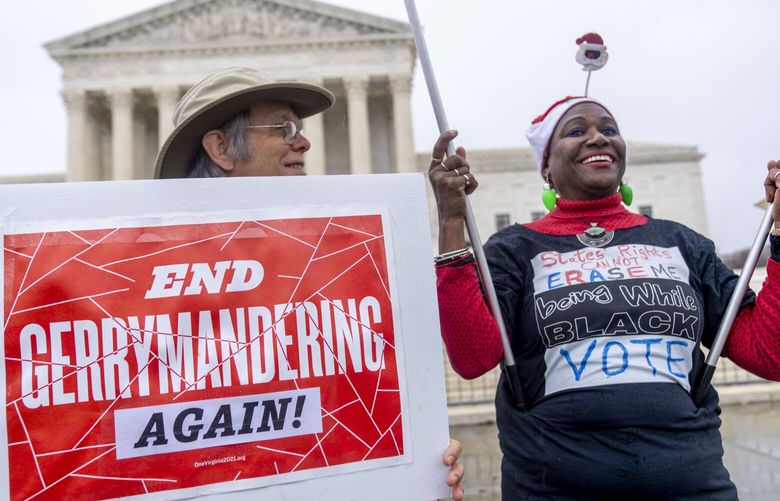 Michael Martin of Springfield, Va., with UpVote Virginia, holds a sign that reads “End Gerrymandering Again!” and speaks with Nadine Seiler of Waldorf, Md., in front of the Supreme Court in Washington, Wednesday, Dec. 7, 2022, as the Court hears arguments on a new elections case that could dramatically alter voting in 2024 and beyond. The case is from highly competitive North Carolina, where Republican efforts to draw congressional districts heavily in their favor were blocked by a Democratic majority on the state Supreme Court. (AP Photo/Andrew Harnik) DCAH108 DCAH108