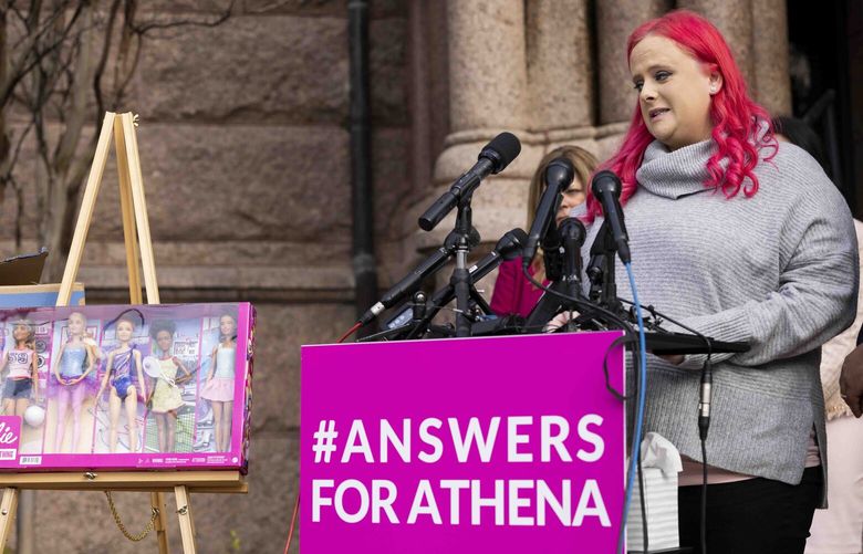 Maitlyn Gandy, mother of 7-year-old Athena Strand, looks at the package that was delivered by a FedEx delivery man authorities say allegedly abducted her daughter last week during a press conference on Thursday, Dec. 8, 2022, outside of the Wise County Courthouse in Decatur, Texas. The package, a You Can be Anything Barbie set, was supposed to be Athena’s Christmas present, Gandy said. (Juan Figueroa/The Dallas Morning News via AP) TXDAM202 TXDAM202