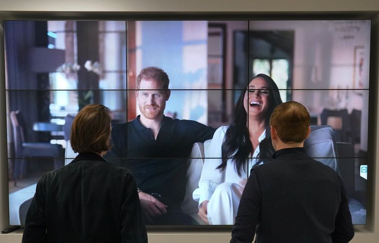 Office workers in London, watch the Duke and Duchess of Sussex’s controversial documentary being aired on Netflix Thursday, Dec. 8, 2022. Britainâ€™s monarchy is bracing for more bombshells to be lobbed over the palace gates as Netflix releases the first three episodes of a new series. The show â€œHarry & Meghanâ€ promises to tell the â€œfull truthâ€ about Prince Harry and his wife Meghanâ€™s estrangement from the royal family. The series debuted Thursday. (Jonathan Brady/PA via AP) LON801 LON801